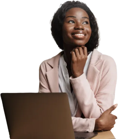 Woman in a pink jacket seated at a laptop.