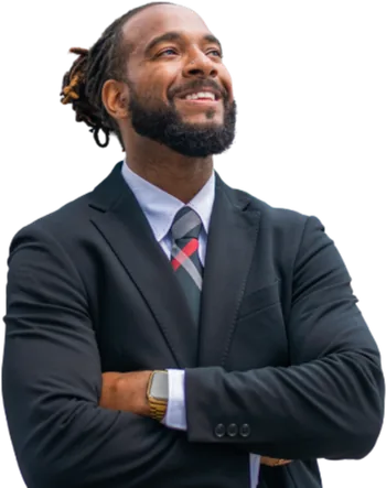 Man in a dark suit and tie with folded arms.