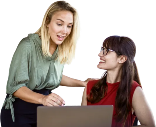 Two women discussing work at a laptop.
