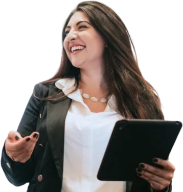 Woman in a black blazer holding a notebook and gesturing.