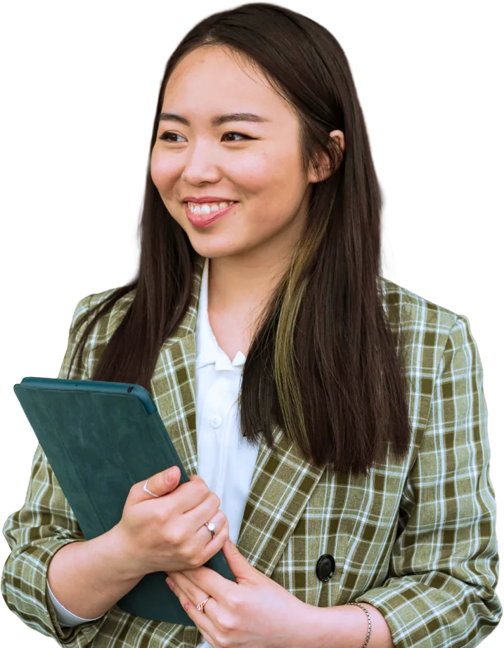 Woman in a green plaid shirt holding a notebook.