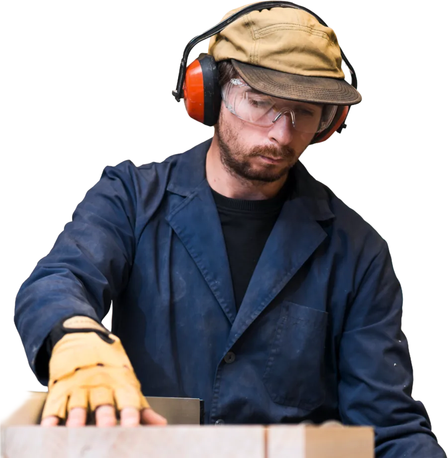 Man wearing ear defenders working at a bench.